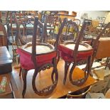 A set of four Victorian mahogany framed balloon back standard chairs with pierced decoration and