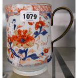 An 18th Century Chinese porcelain mug decorated in iron red and blue with stylised flowerheads, with