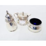 A silver three piece condiment set by Goldsmiths & Silversmiths with decorative cast rims, blue