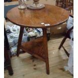 A 65cm diameter late Georgian polished pine cricket table with triangular undertier, set on