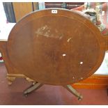 An 89cm diameter reproduction mahogany and strung tilt-top table, set on turned pillar and tripod