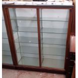 A 1.23m vintage stained wood and glazed shop display cabinet with two banks of shelves enclosed by