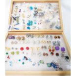 Two wooden trays containing a collection of assorted costume jewellery ear-rings