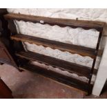 A 1.19m late 18th Century oak wall mounted three shelf open plate rack with scalloped aprons and