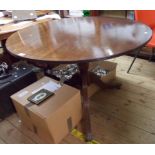 A 106cm diameter reproduction mahogany and strung tilt-top table, set on turned pillar and reeded