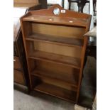 A 62cm early 20th Century stained wood three shelf open bookcase with heart pierced top