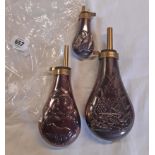 Three reproduction embossed copper and brass powder flasks