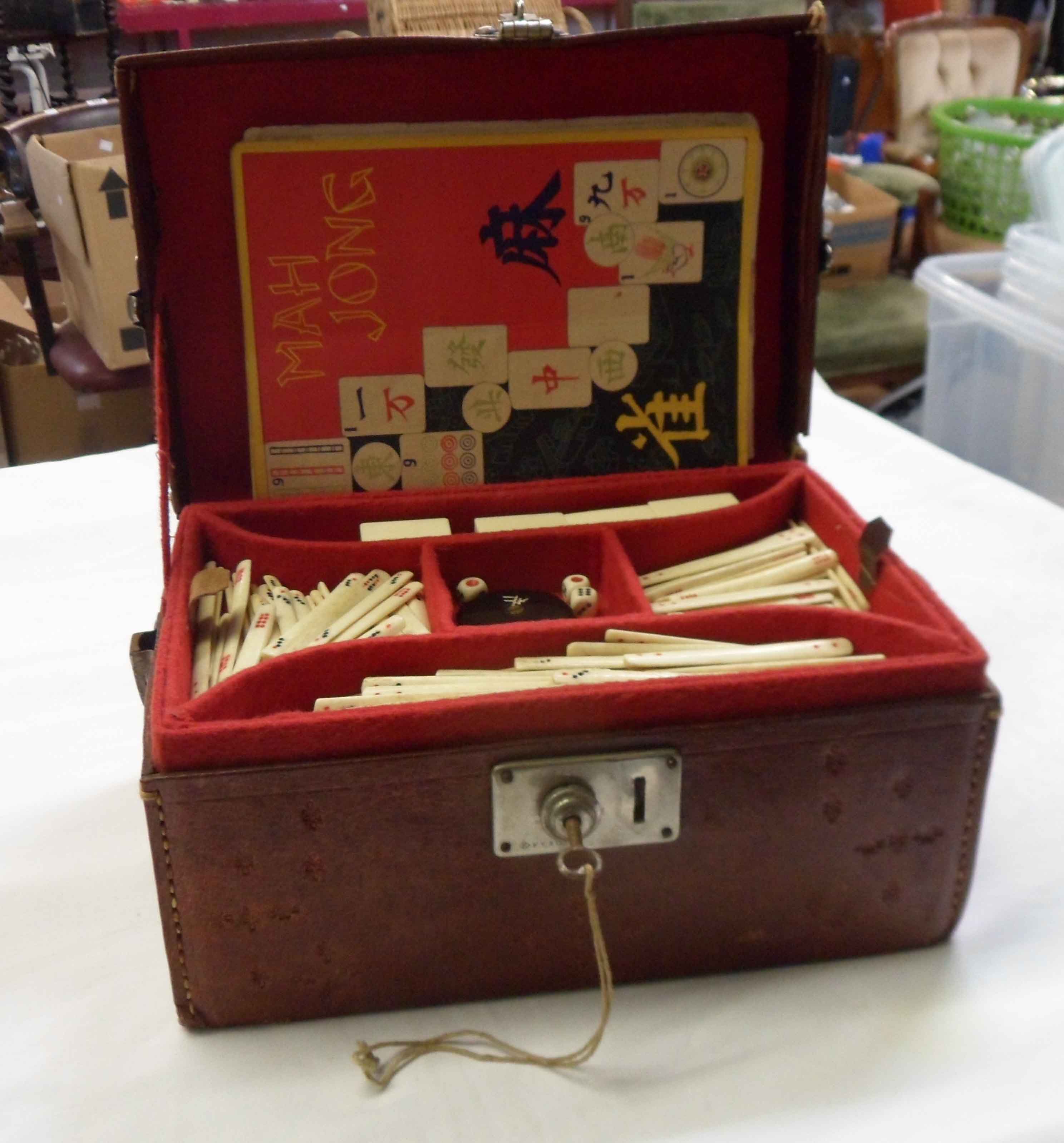 A vintage Japanese bone and bamboo Mah Jong set with counters, dice, and instructions in tooled