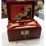 A vintage Japanese bone and bamboo Mah Jong set with counters, dice, and instructions in tooled
