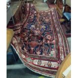 A large Iranian wool rug with mirrored lion and other motifs in a repeat border - 285cm X 150cm