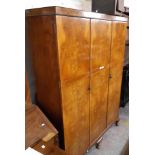 A 1.48m 1930's walnut book match veneered Aw-lyn triple wardrobe with hanging space, shelves and