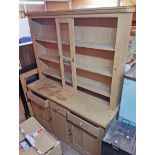 A 1.8m waxed pine dresser base with three frieze drawers and flanking panelled cupboard doors under,