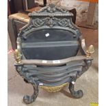A 45cm Georgian style cast iron and brass mounted ornate fire grate with decorative pediment to