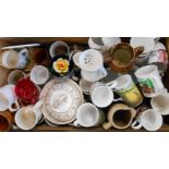 A wooden drawer containing commemorative and other mugs, etc.