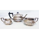 A late Victorian silver three piece tea set of semi-reeded design with lightly engraved initials