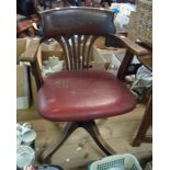 A vintage stained wood framed curved back swivel office elbow chair with studded red leatherette