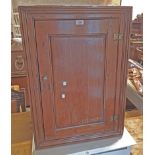 A 57cm antique waxed pine wall hanging corner cabinet with shaped shelves enclosed by a panelled