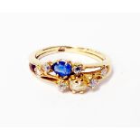 A marked 18 yellow metal ring set with tiny diamonds, seed pearl and sapphire