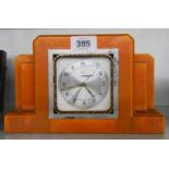 An Art Deco orange glazed pottery clock case with replacement movement - bezel corroded