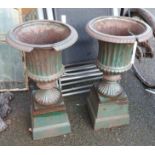 A pair of cast iron urns - some damage