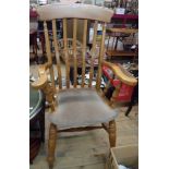 A 20th Century stained wood high lath back Windsor style elbow chair with upholstery to seat, set on