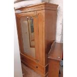 A 1.37m Victorian polished pine wardrobe with rounded moulded cornice and re-hinged arched mirror