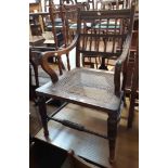 A late 19th Century mahogany framed spindle back elbow chair with remains of rattan seat panel,