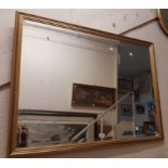 A modern gilt framed bevelled oblong wall mirror - 23cm X 110cm