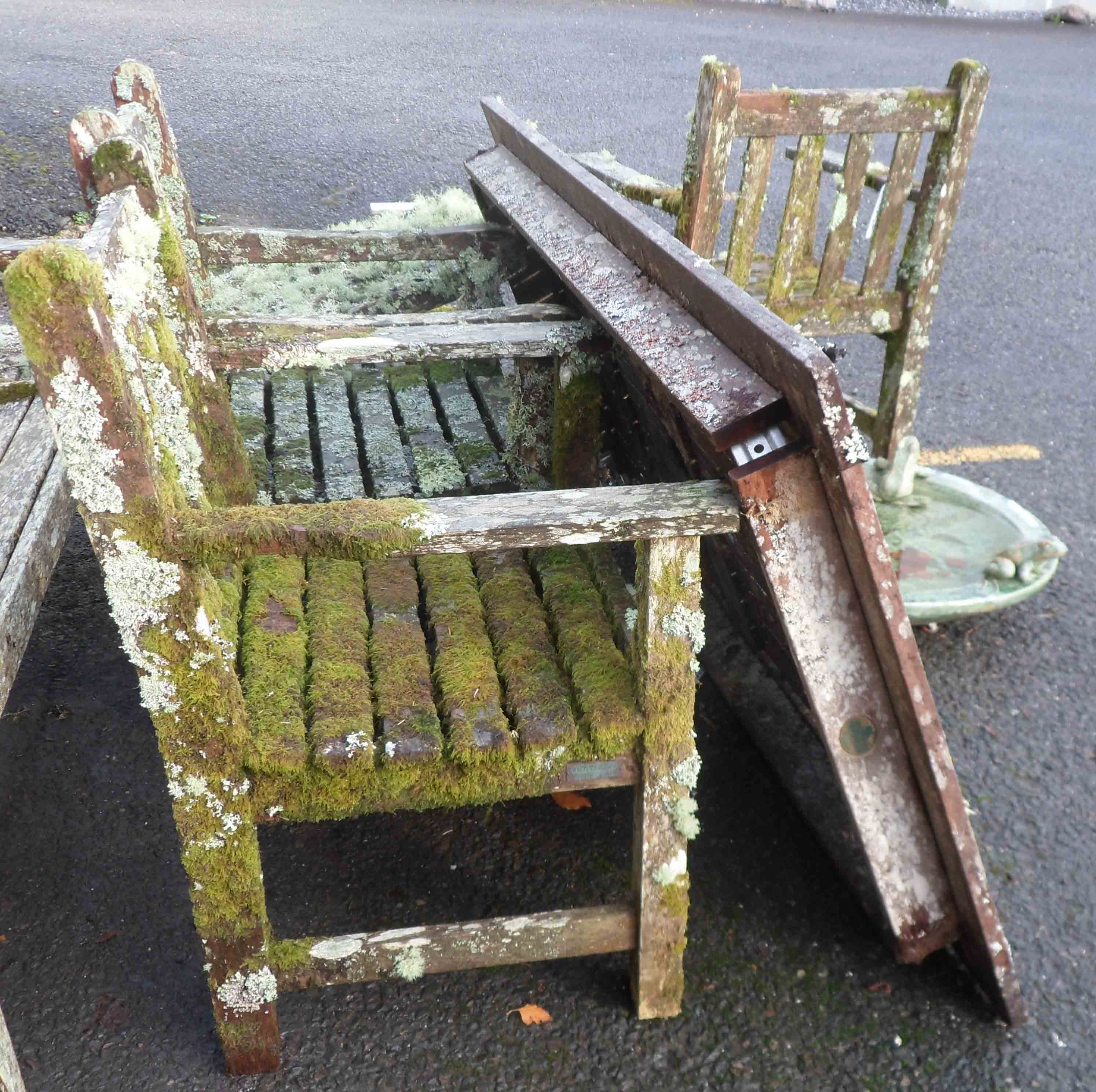 A Barlow Tyrie teak table and four chairs covered in lichen