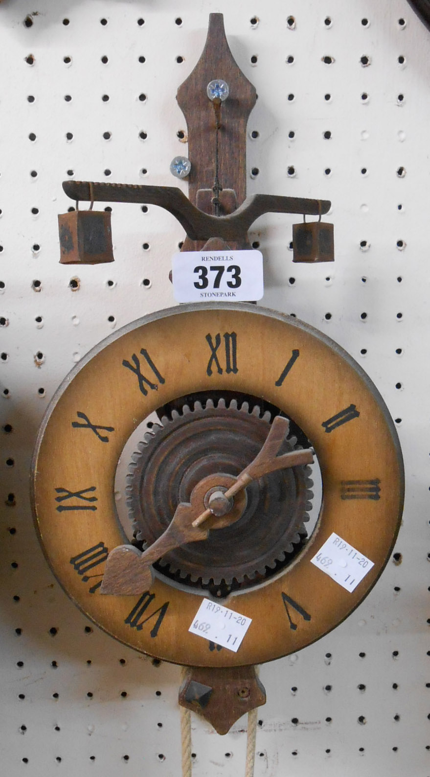 A reproduction of a wooden framed timepiece with stone and pumice weights