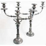 A pair of 53.5cm high antique silver plated copper twin branch three light candelabra with