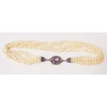 A multi-string fresh water pearl necklace with marked 925/18ct pale purple stone set clasp