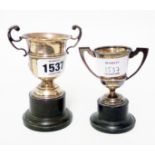 Two small silver trophy cups on black plastic socle bases