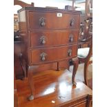 A 46cm reproduction mahogany bow front bedside chest of three long drawers, set on cabriole legs