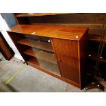 A 1.22m vintage teak and mixed wood book cabinet with cupboard to one end and shelves enclosed by
