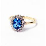 A hallmarked 375 gold ring, set with central topaz and diamond border - 0.2ct TDW