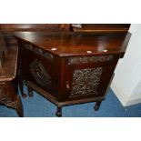 A 20TH CENTURY CARVED OAK CANTED SINGLE DOOR CUPBOARD, the central panel with foliate and Dragon