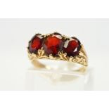 A 9CT GOLD THREE STONE GARNET RING, designed as three graduated oval shape garnets to the