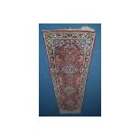 A 20TH CENTURY WOOLLEN KERMAN STYLE RED, BLUE AND CREAM CARPET RUNNER 316cm x 85cm (sd and tassels