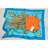 A SILK SCARF AND A HERMES BOX, the scarf designed with a light blue centre and darker blue border,