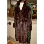 A LADIES BROWN MUSQUASH KNEE LENGTH COAT, having shawl collar, turnback cuffs, hook and eye