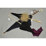 THREE LATE 19TH TO EARLY 20TH CENTURY BLACK PARASOLS, the first with carved bone handle, pink