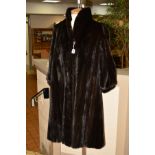 A DARK RANCH MINK COAT, with lapel collar, bishop sleeves, hook fastenings believed to be size 12