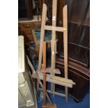 A BEECH FOLDING ARTISTS EASEL together with four various measuring tools (5)