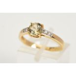 A 9CT GOLD GEM RING, designed as a central circular yellow/green gem assessed as a synthetic spinel,