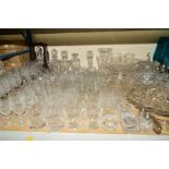 A COLLECTION OF UNMARKED CUT GLASS including one bottle tantalus, four decanters, six champagne
