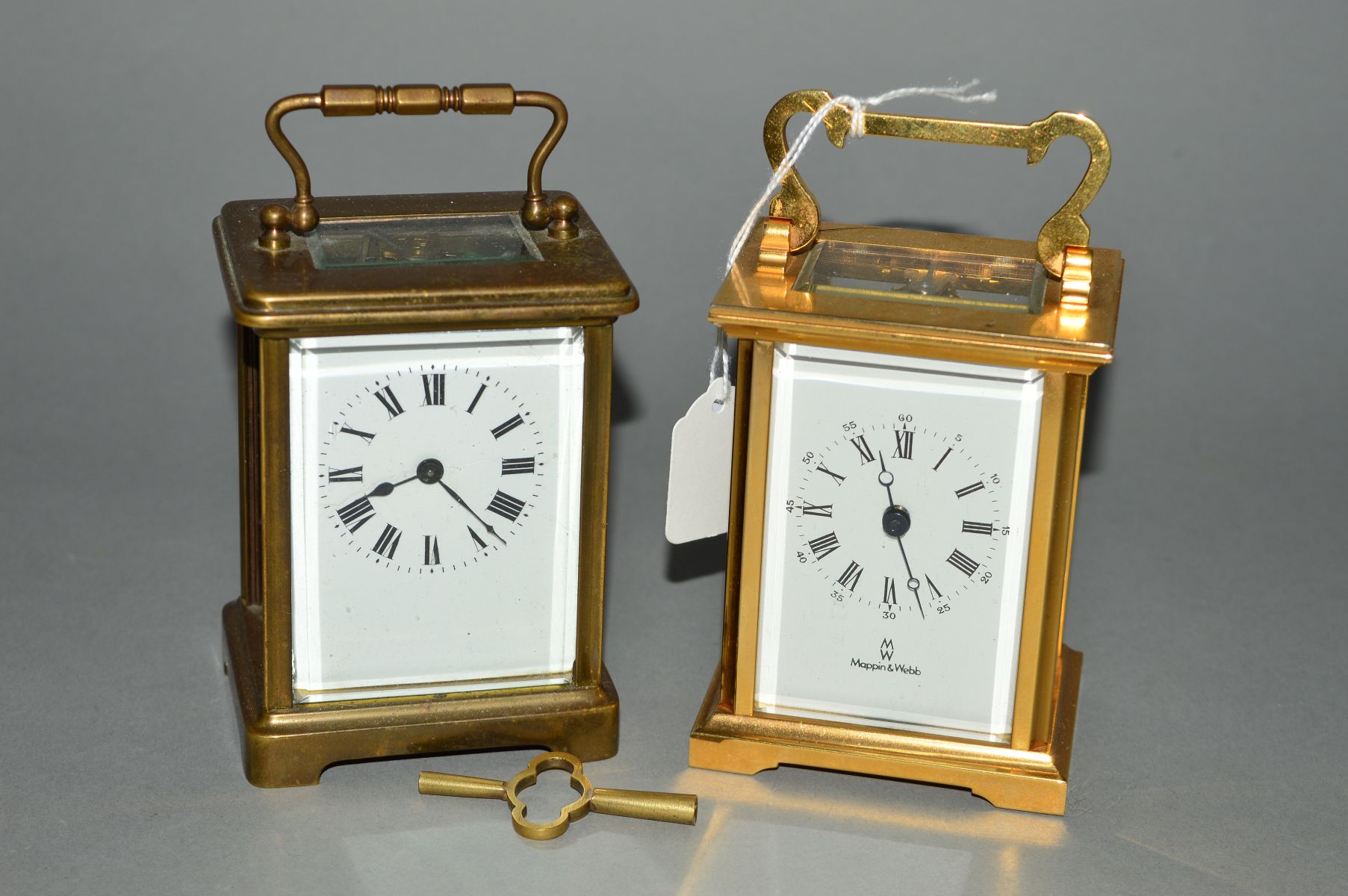 TWO BRASS CARRIAGE CLOCKS, to include a Mappin & Webb example, both with white faces, black Roman