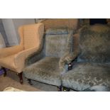 A LATE 19TH/EARLY 20TH CENTURY UPHOLSTERED WING BACK ARMCHAIR on casters together with a green