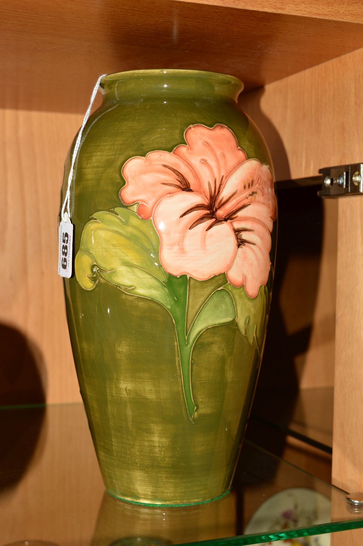 A MOORCROFT POTTERY VASE, 'Hibiscus' pattern on green ground, 'Queen Mary' label to base and