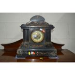 A LATE 19TH CENTURY SLATE MANTEL CLOCK, brass mounts of cherubs in a woodland scene, pair of